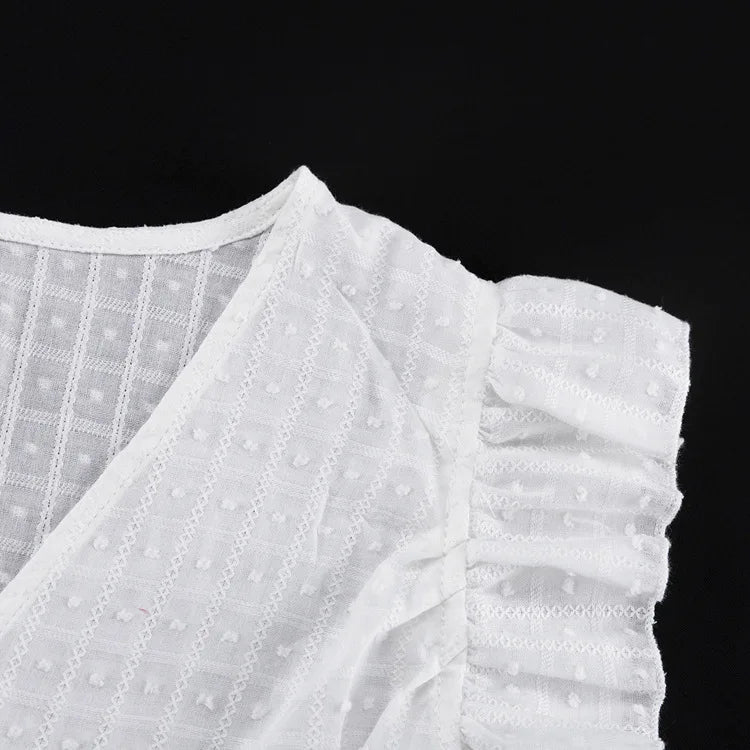 White blouse with ruffled details on a black background