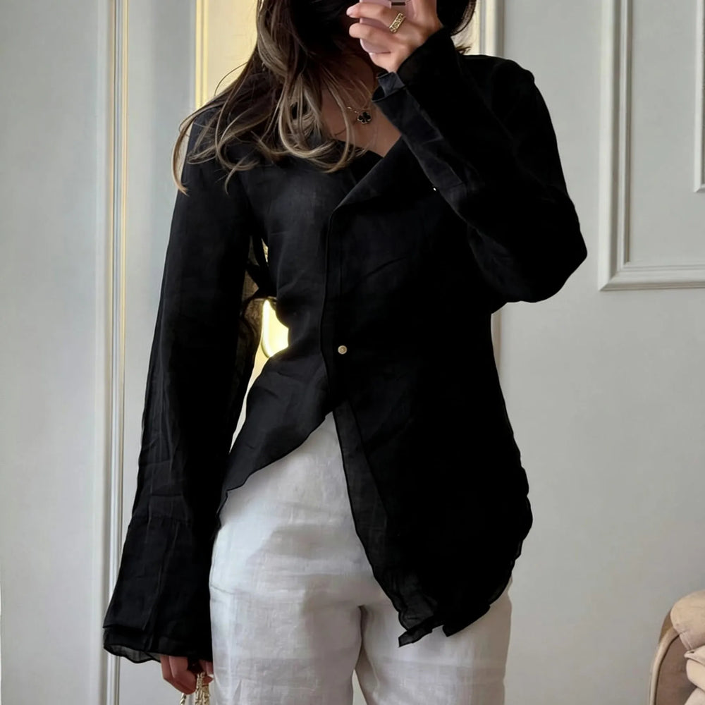 Person wearing a black jacket over a white outfit in an indoor setting