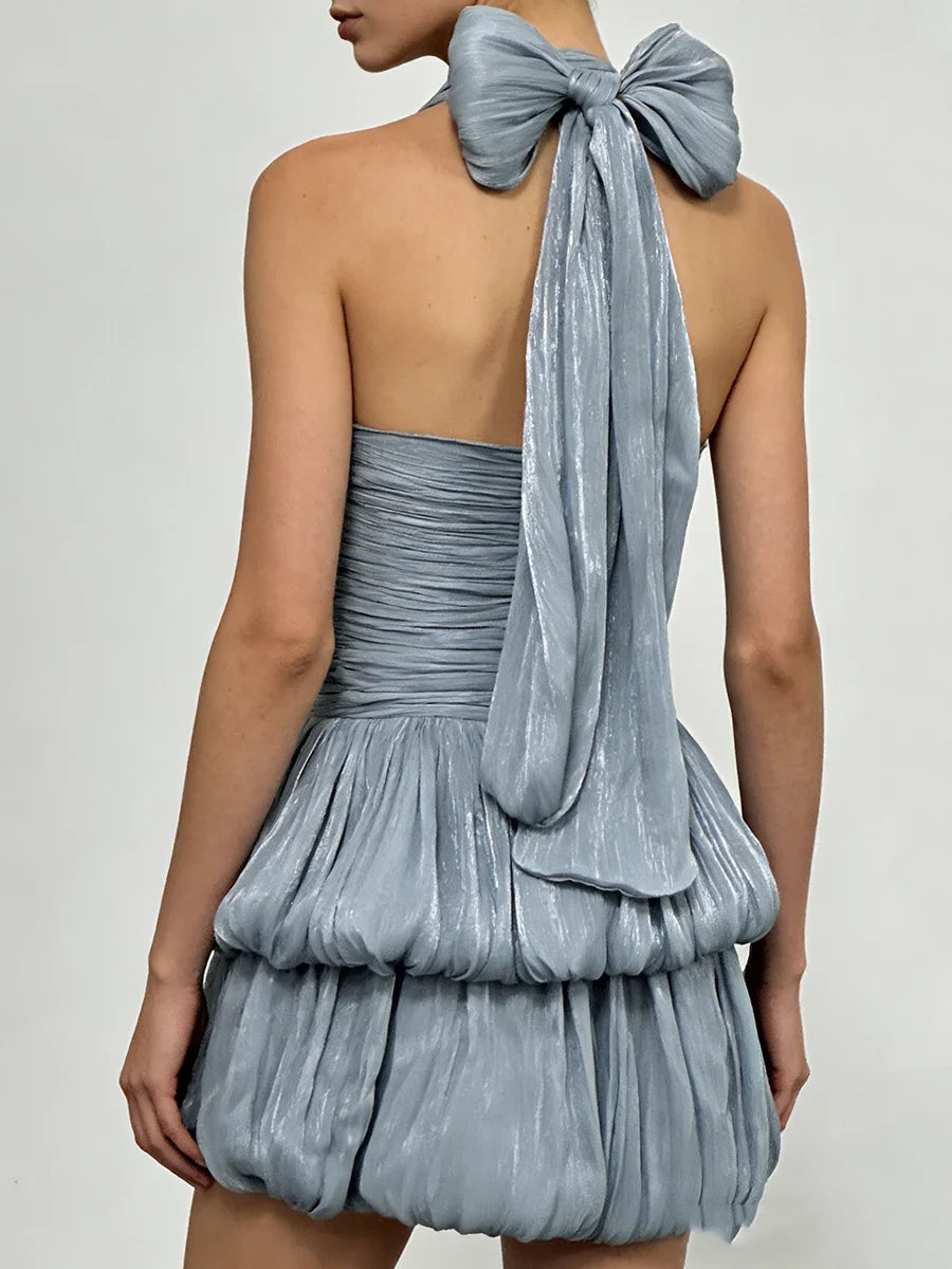 Blue dress with a large bow detail on a plain background