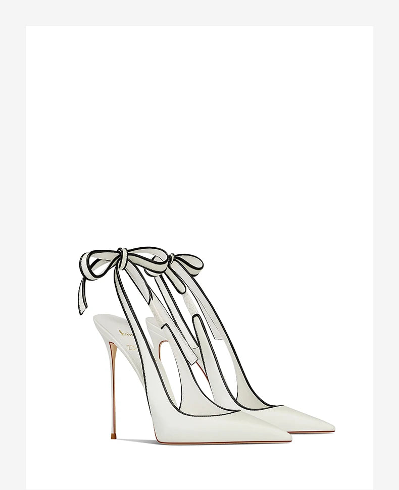 White high-heeled shoes with bow detail on a white background