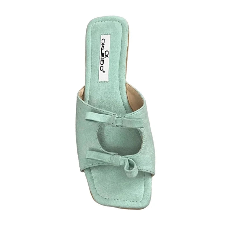 Mint green sandal with a bow on a white background