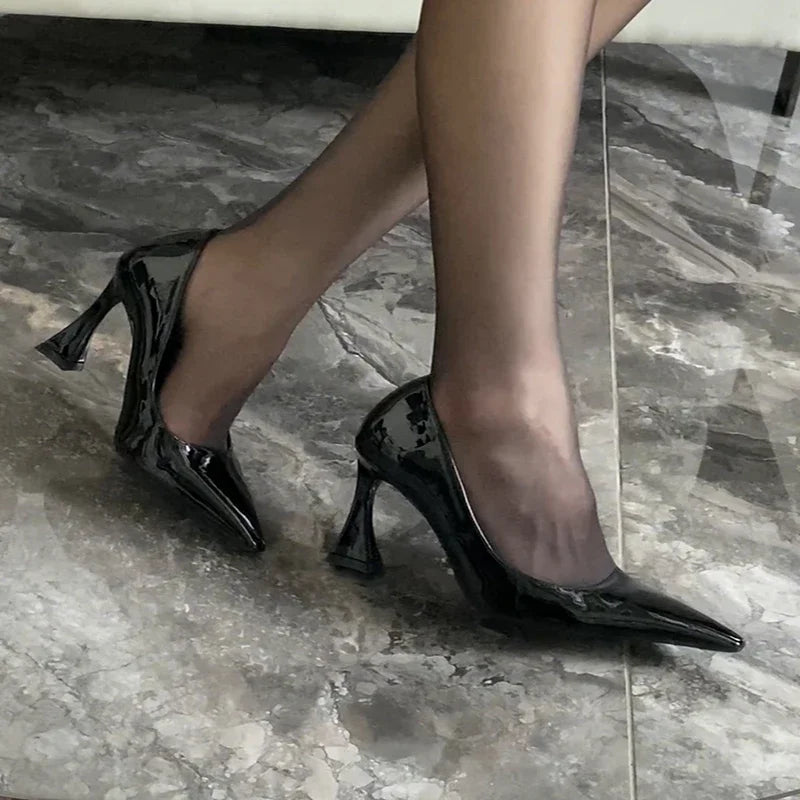Black high-heeled shoes on a marble floor