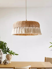 A Japanese Wabi-Sabi hemp rope pendant light with a woven design, casting a warm glow in a minimalist living room. C