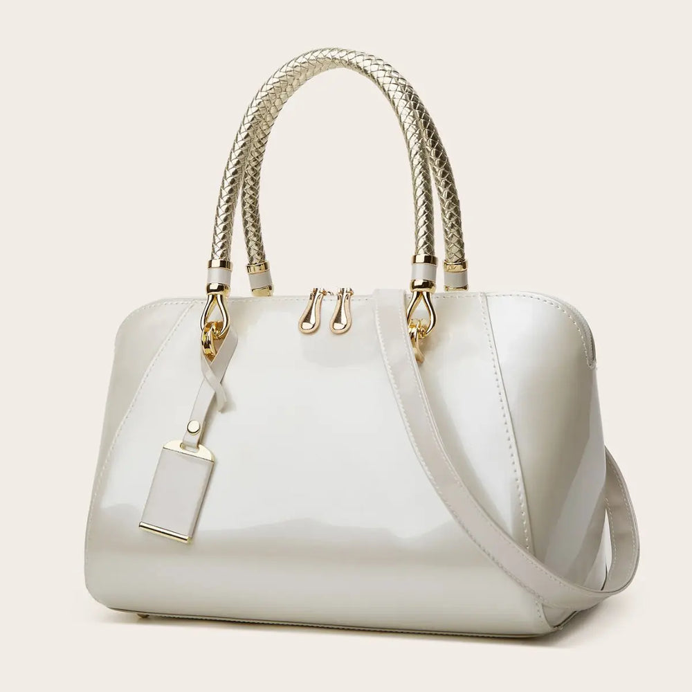 White patent leather Boston bag with braided handles and shoulder strap.