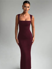 Woman wearing a burgundy evening gown against a gray background
