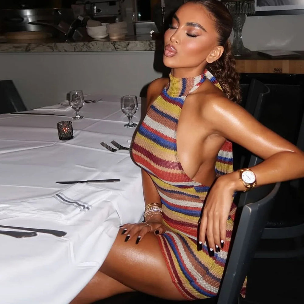 Woman in a striped knit halter mini dress at a table