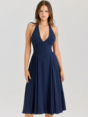 Navy blue halter neck dress on a model against a light gray background