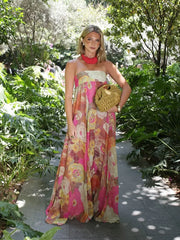 Woman in a floral dress holding a woven bag in a garden setting