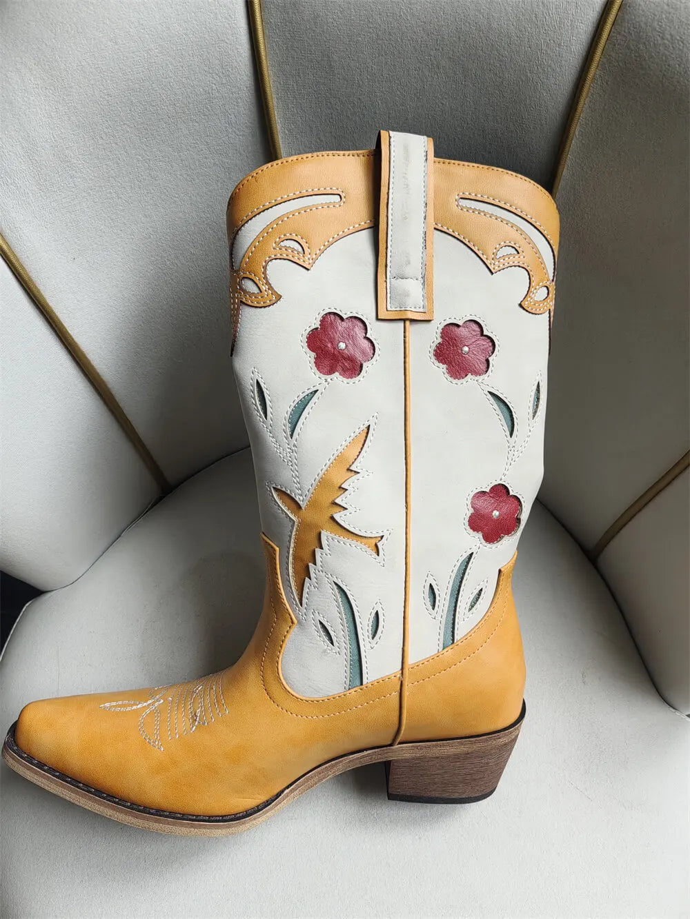 Pointed toe embroidered floral western boots in yellow.
