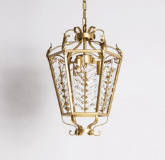 Decorative gold pendant light with intricate design on a white background
