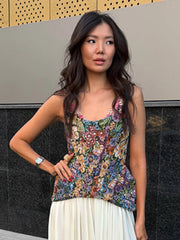 Close-up of a woman wearing a floral print peplum top and white maxi skirt