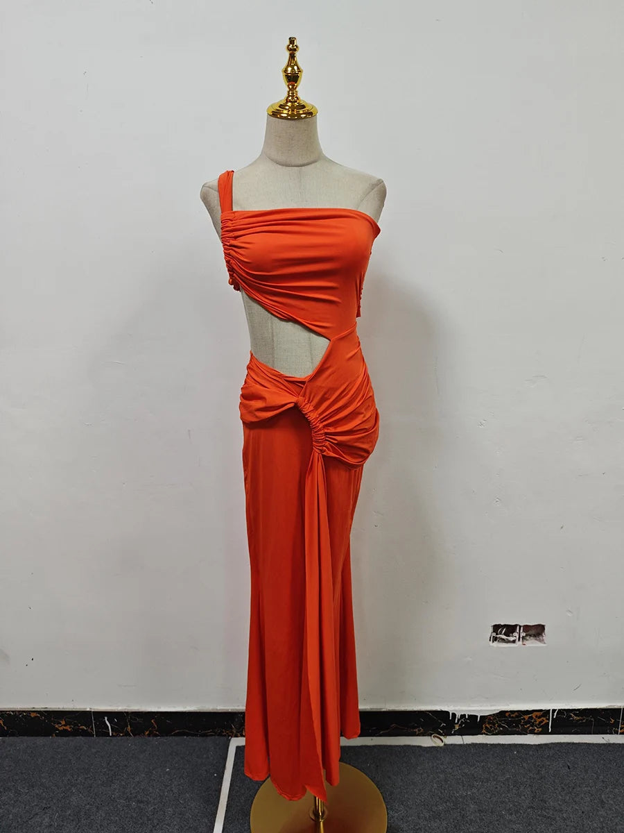 Orange evening gown on a mannequin against a white wall.