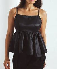 Black peplum top worn by a person on a white background