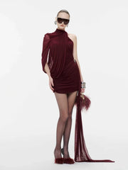 Woman wearing a burgundy dress with feather details on a white background
