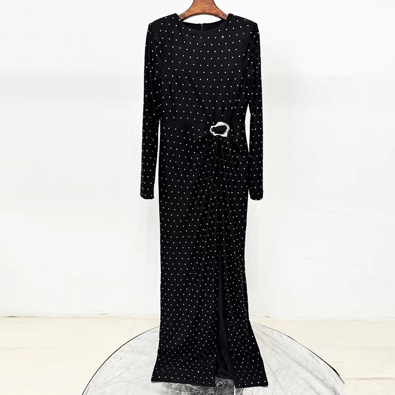 Black beaded polka dot maxi dress on a hanger, showing the front detail and slit.