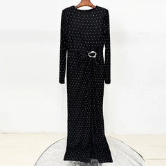 Black beaded polka dot maxi dress on a hanger, showing the front detail and slit.