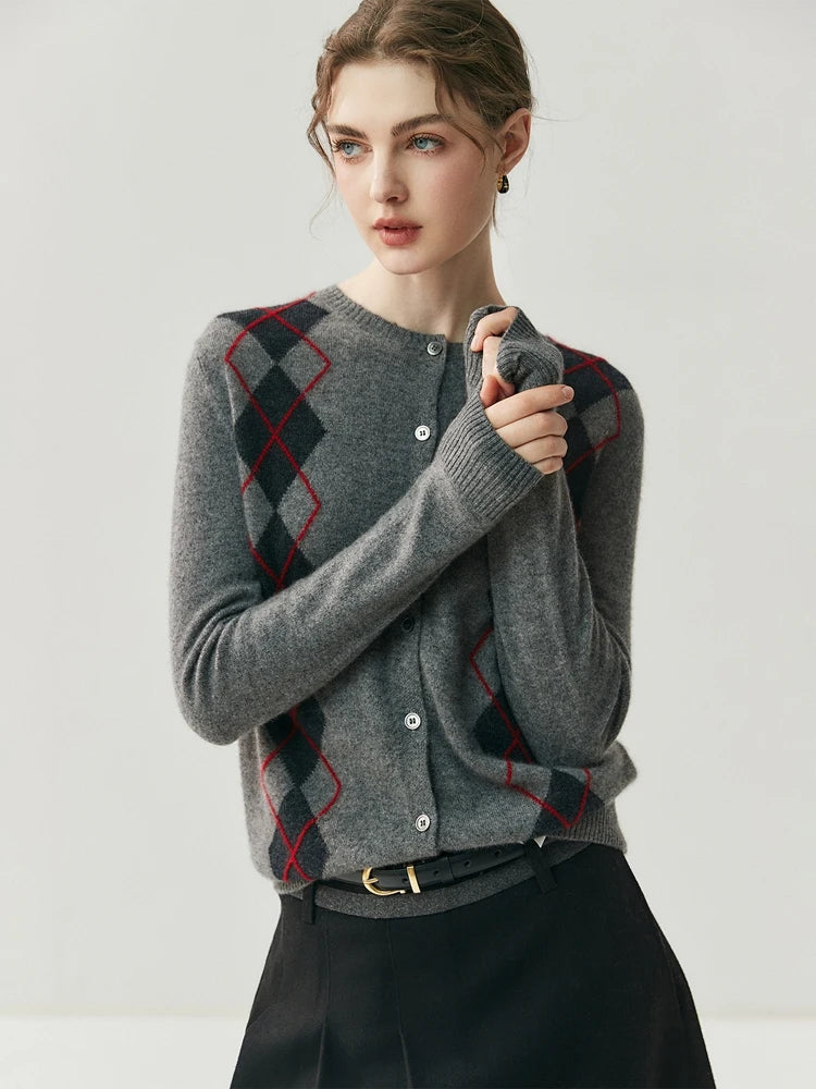 Woman wearing a gray argyle sweater against a plain background