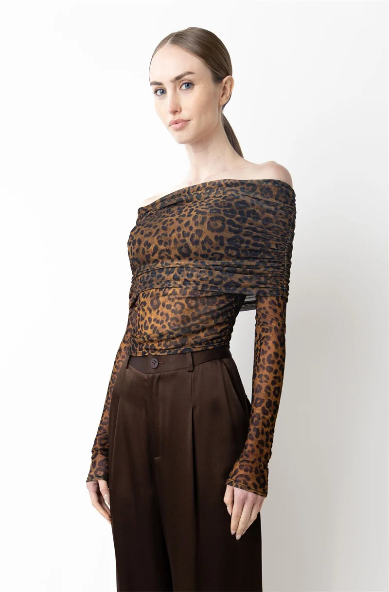 Woman wearing a leopard print off-shoulder top and brown pants