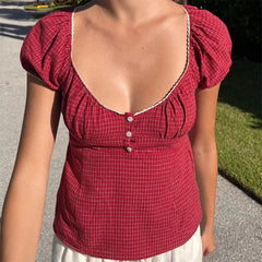 Red checkered top with puff sleeves worn by a person outdoors.