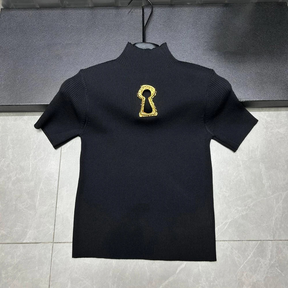 Black turtleneck sweater with a gold keyhole design on a gray background