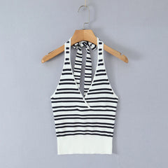 Black and white striped halter top on a wooden hanger against a gray background