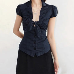 Navy blue blouse with a bow detail on a plain background