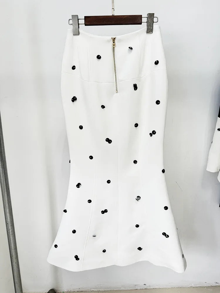 White skirt with black polka dots on a hanger against a white background