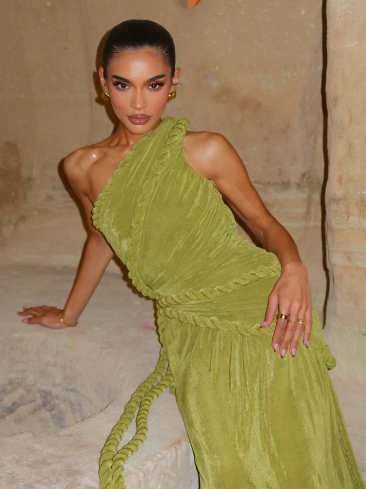 Woman wearing a green one-shoulder dress in an indoor setting