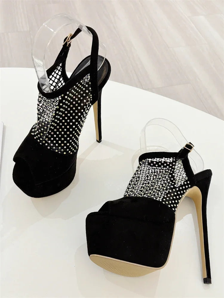 Black high-heeled shoes with rhinestone detailing on a white background