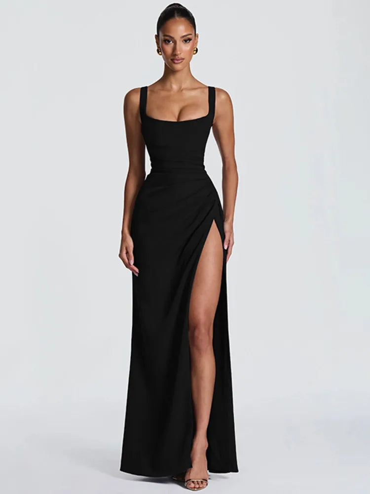 Woman wearing a black sleeveless gown with a high slit on a white background