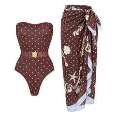 Strapless polka dot one-piece swimsuit with a belted waist, paired with a coordinating polka dot skirt.