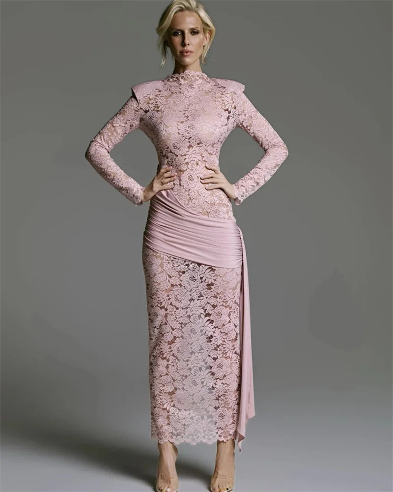 Woman wearing a pink lace dress against a gray background
