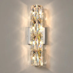 An elegant crystal wall light with a long arm and a decorative shade, adding a touch of luxury to a bedroom.