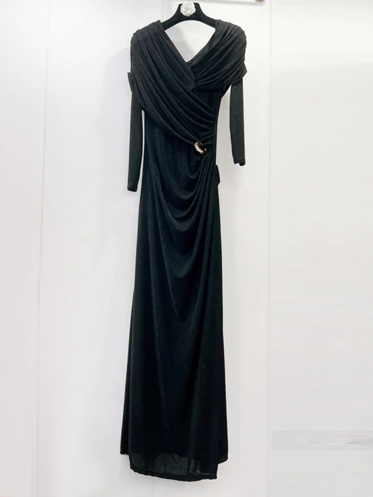 Black evening gown on a hanger against a white background