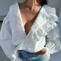 White blouse with ruffled sleeves and lace details worn by a person.