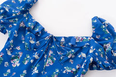 Close-up of square neckline and puff sleeve detail on floral midi dress