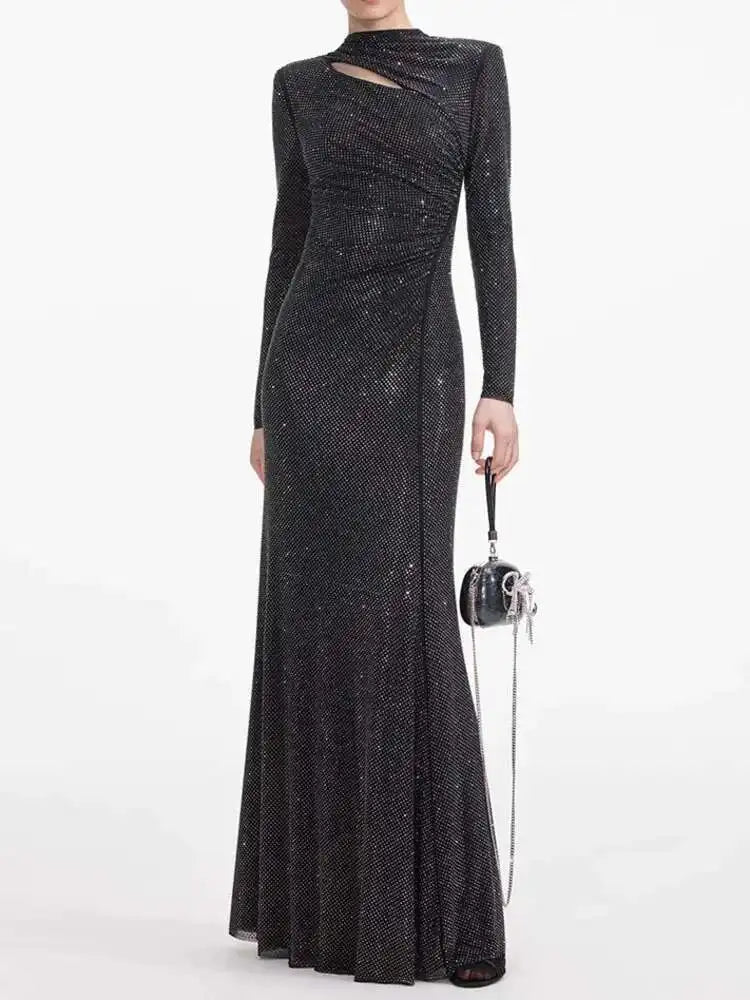 Black sequin evening gown with long sleeves on a white background