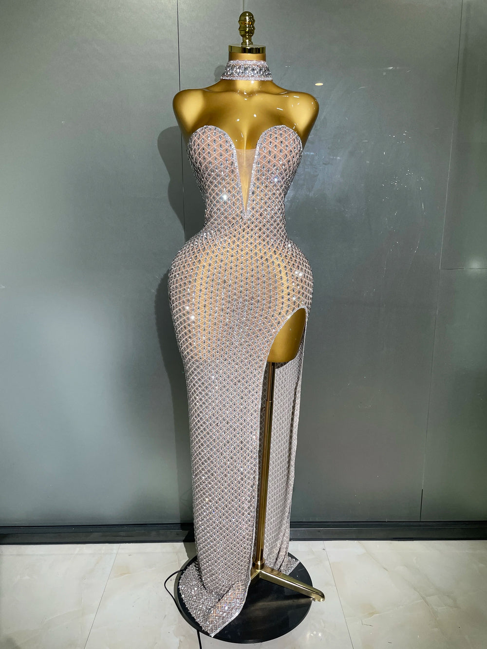 Sparkling evening gown on a mannequin against a plain background