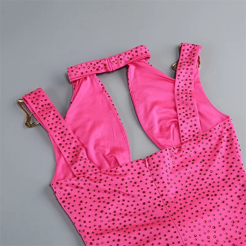 Pink swimsuit with gold embellishments on a gray background