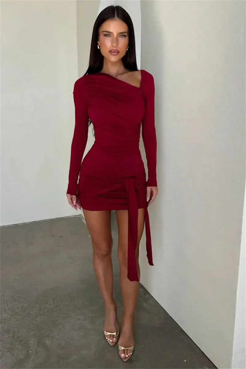 Woman wearing a red dress with long sleeves against a plain background