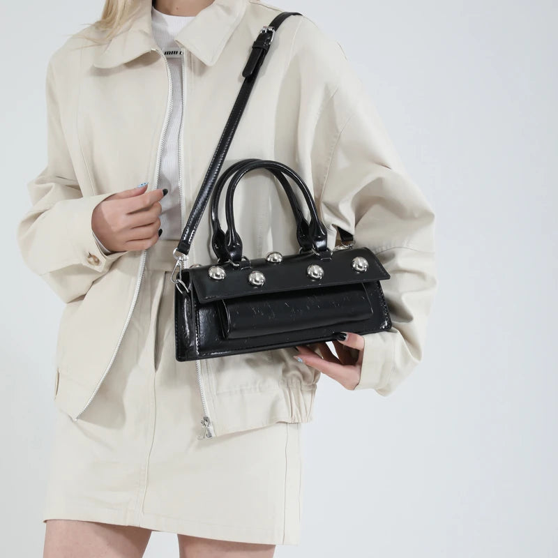 Black riveted PU leather top handle bag held by model