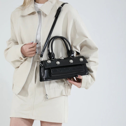 Black riveted PU leather top handle bag held by model