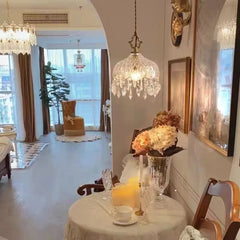 A modern crystal pendant light with LED bulbs, casting a warm glow in a stylish living room.  Golden Atelier 3