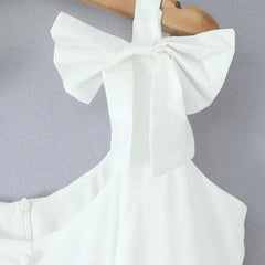White sleeveless top with a large bow detail on a gray background
