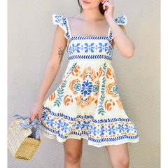 Woman wearing a colorful patterned dress against a plain background