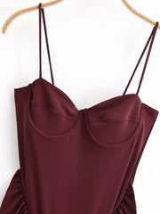 Maroon slip dress on a hanger against a white background