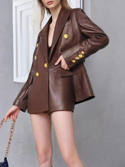 Brown leather suit with gold buttons worn by a person against a gray background