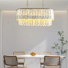 A beautiful shell chandelier with LED lights hanging in a modern living room, creating a coastal-inspired ambiance.  Golden Atelier 2