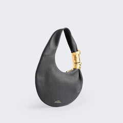 Black grained leather half moon shoulder bag with sculpted gold face hardware detail, side view