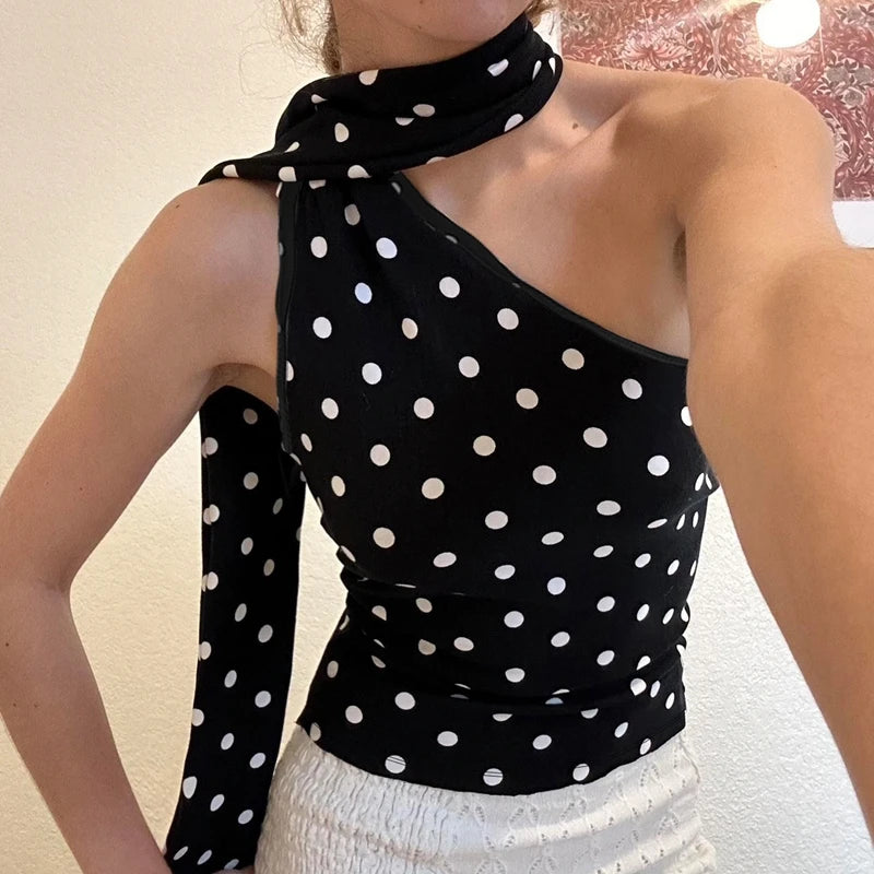 Black polka dot top worn by a person with a neutral background